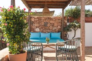 a patio with a table and chairs and a blue couch at ES CUCONS RURAL HOTEL in San Antonio