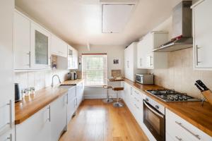 uma cozinha com armários brancos e piso em madeira em The Mews Flat, near Clifton Suspension Bridge em Bristol