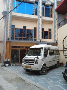 a white van parked in front of a building at Hotel CM Palace - Pure Vegetarian 