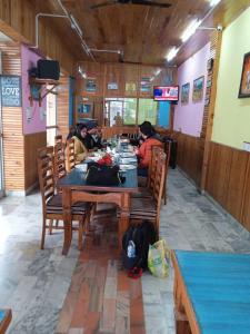 two people sitting at a table in a restaurant at Hotel CM Palace - Pure Vegetarian 