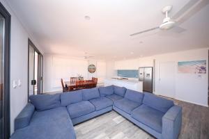 a living room with a blue couch and a kitchen at Exmouth Marina Escape in Exmouth