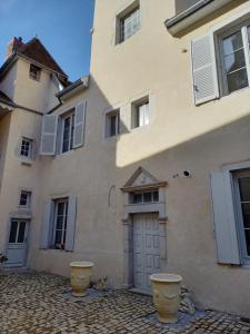 a building with two large pots in front of it at Les Meublés du Colombier in Lons-le-Saunier