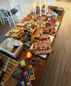 a long table with many plates of food and candles at Kaptenshuset Hotell in Kivik