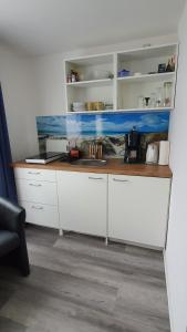 eine Theke mit einem Aquarium in einer Küche in der Unterkunft Appartementhaus Eiergrogstube in Helgoland