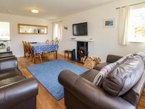 sala de estar con sofá y mesa en Viking Cottage, en Lochailort