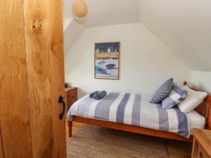 a bedroom with a bed with a striped blanket at Viking Cottage in Lochailort