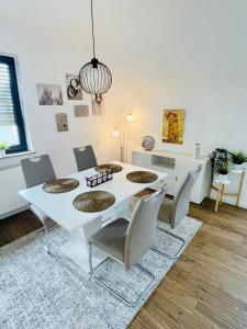 a dining room with a white table and chairs at Allegra Appartements in Nohfelden