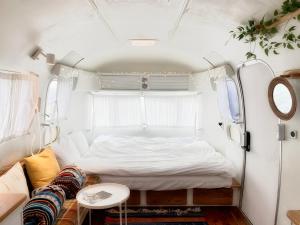 a small bedroom with a bed and a couch at BeachBoys - Retro Caravan AirStream in Jeju