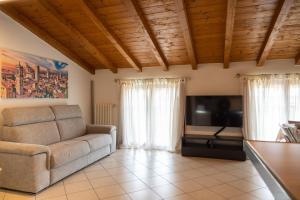 ein Wohnzimmer mit einem Sofa und einem Flachbild-TV in der Unterkunft Incantevole Mansardato 75mq vicino a BGY in Zanica