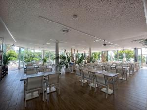 - une salle à manger avec des tables, des chaises et des fenêtres dans l'établissement Costalita Apartment - Pool by the Beach, à Estepona