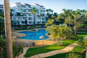 - une vue aérienne sur un complexe avec une piscine et des palmiers dans l'établissement Costalita Apartment - Pool by the Beach, à Estepona
