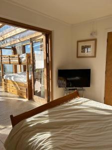 a bedroom with a bed and a view of a balcony at The Old Lookout in Osmington