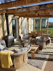 patio al aire libre con sofás y estufa de leña en The Old Lookout en Osmington
