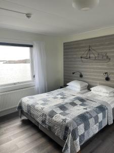 a bedroom with a bed with a boat on the headboard at Hotell Fisketången in Kungshamn