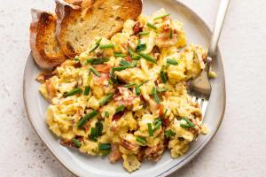 a plate of scrambled eggs with bread and a fork at B&B Majhen in Kopačevo