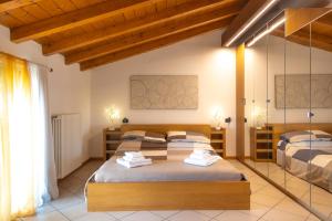 2 Betten in einem Zimmer mit Holzdecken in der Unterkunft Incantevole Mansardato 75mq vicino a BGY in Zanica