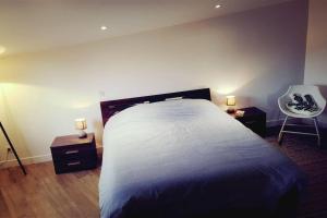 a bedroom with a large bed with two night stands and a chair at Magnifique bergerie corse du 17eme Siècle à proximité des plages in Eccica-Suarella