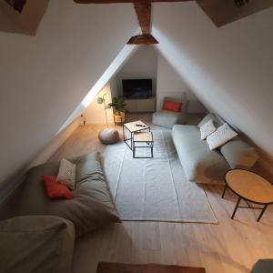 - un salon mansardé avec un canapé et une table dans l'établissement Les appartements Hyper centre, à Strasbourg