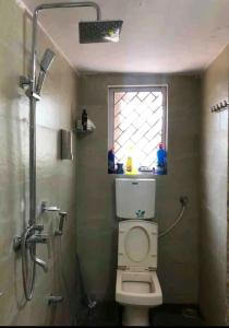 a bathroom with a shower and a toilet and a window at BnBBuddy- Great Escape@Karjat, Maharashtra in Karjat
