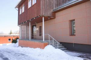 un edificio de ladrillo con una escalera en la nieve en ACK būve, en Alūksne