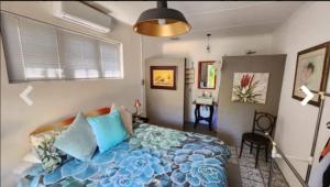 a bedroom with a bed with blue pillows at Stay @ Dudok in Oudtshoorn