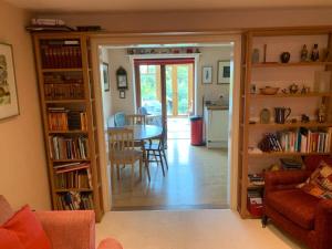 a living room with a table and a dining room at Sweet Modern Country Cottage with Garden in Frome