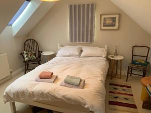 a bedroom with a bed with towels on it at Sweet Modern Country Cottage with Garden in Frome