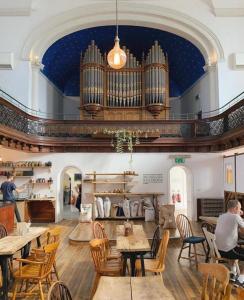 a large room with tables and a large organ at Sweet Modern Country Cottage with Garden in Frome