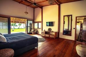 a bedroom with a bed and a television in it at Baha Baha Villa Sailo Mentawai in Katiet
