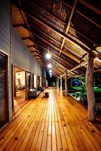 a large deck with a wooden floor and a building at Baha Baha Villa Sailo Mentawai in Katiet