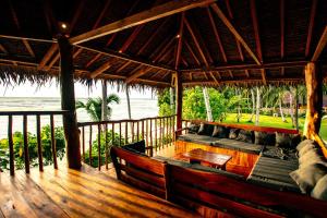 a porch of a resort with a table and benches at Baha Baha Villa Sailo Mentawai in Katiet