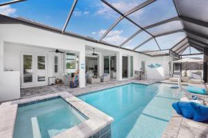 una piscina cubierta con techo de cristal en 2022 built home with pool/spa and walk to Mackle Park, en Marco Island