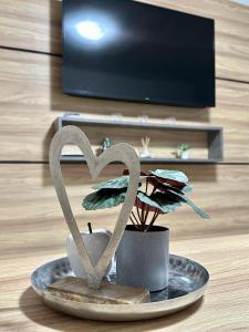 um par de esculturas de coração em um prato ao lado de uma planta em Apart 8 em Sandanski