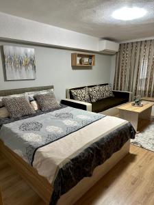 ein Schlafzimmer mit einem großen Bett und einem Sofa in der Unterkunft Apart 8 in Sandanski
