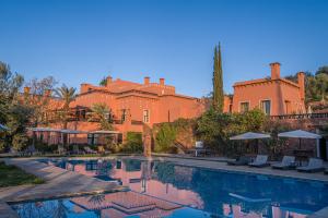 a resort with a swimming pool in front of a building at Kasbah Agounsane Hotel & Spa in Ourika