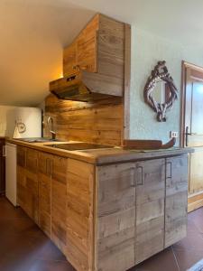 a kitchen with wooden cabinets and a sink at Monica's apartment Mansarda - Stella Alpina in Sauze dʼOulx