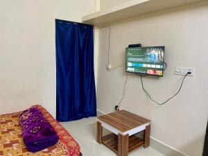 a room with a couch and a tv and a table at The Lakeview Apart-Hotel in Agartala