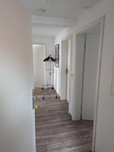 - un couloir avec une chambre dotée de murs blancs et de parquet dans l'établissement Ferienwohnung Beck, à Ansbach