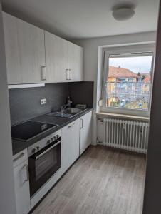 a kitchen with a sink and a stove and a window at Ferienwohnung Beck in Ansbach