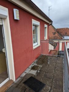 a red house with a balcony in front of it at Ferienwohnung Beck in Ansbach