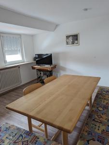 a dining room with a wooden table and a desk at Ferienwohnung Beck in Ansbach