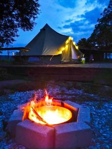 a fire pit with a tent in the background at BELLTENT SAVICA in Zagreb