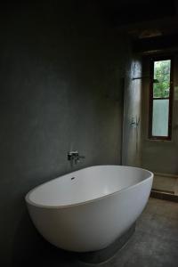 a large white bath tub in a bathroom at Wild Grass Nature Resort in Sigiriya