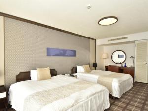 um quarto de hotel com duas camas e um espelho em Shimoda Prince Hotel em Shimoda
