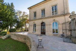 un gran edificio de piedra con una puerta y un patio en Domaine Mas Bégon, en Aigues-Vives