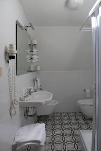 a white bathroom with a sink and a mirror at Hotel Mare Blu in Francavilla al Mare