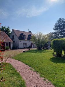 uma grande casa branca com um jardim de relva em Gîte de la Besbre em Saint-Pourçain-sur-Besbre