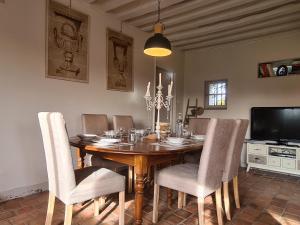 uma sala de jantar com uma mesa de madeira e cadeiras em Gîte de la Besbre em Saint-Pourçain-sur-Besbre