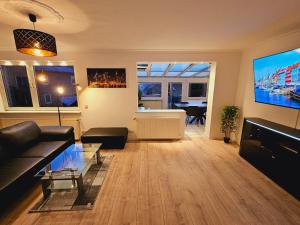 a living room with a couch and a flat screen tv at B02 Schöne Apartments in Barsinghausen in Barsinghausen