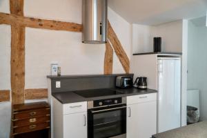 a kitchen with a stove top oven next to a refrigerator at Brooklyn Penthouse in Copenhagen